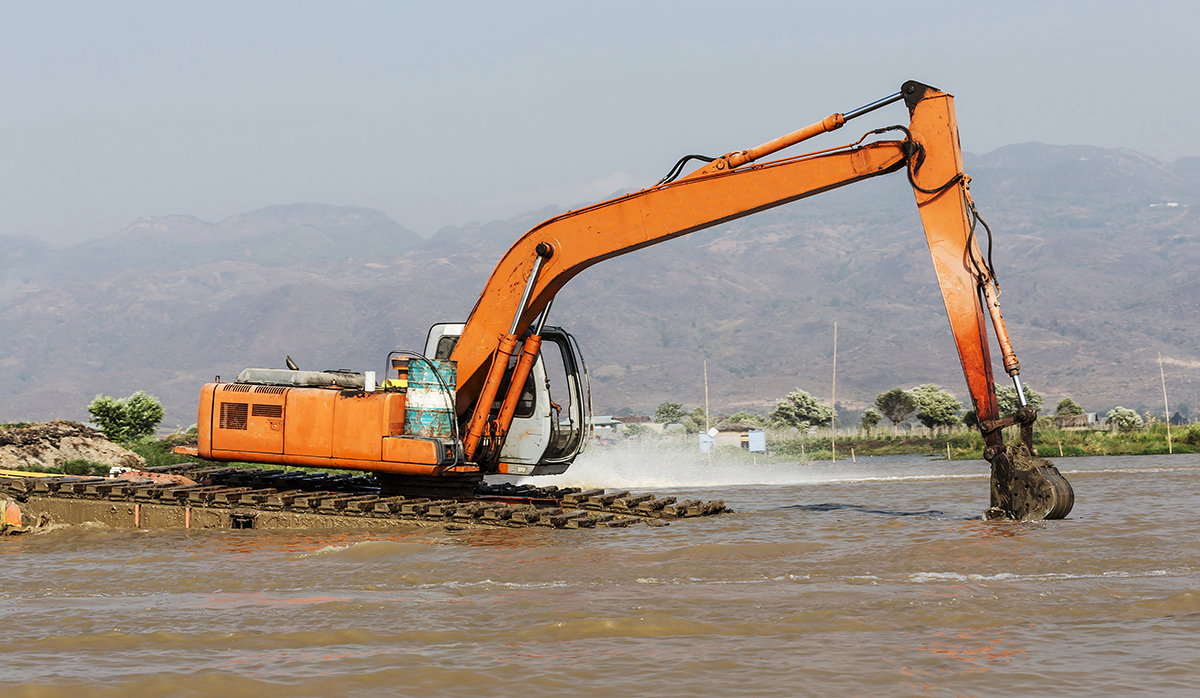 excavator removing dredging sediments